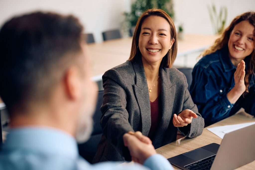 A smiling business professional shaking hands with another person